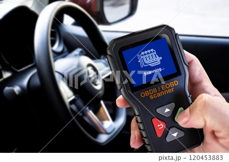 OBDII Scanner in use by auto mechanic for reading fault code of the car engine system 120453883