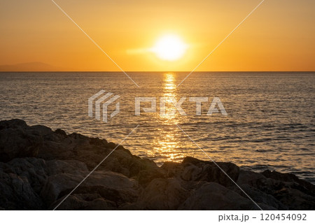 Sunset over the Mediterranean sea, seen from the coast in Torremolinos, Andalusia, Spain. 120454092