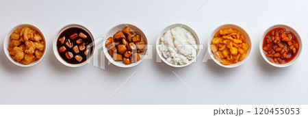 Variety of colorful dishes arranged neatly on a white surface showcasing diverse cuisine options 120455053