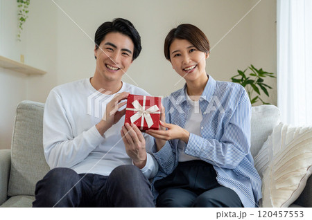 プレゼントを持って笑顔の男女 120457553