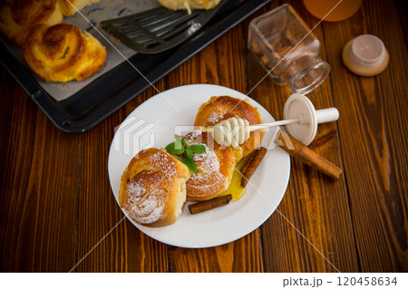 Pastries. Sweet buns with cottage cheese filling and honey in a plate on a wooden table 120458634