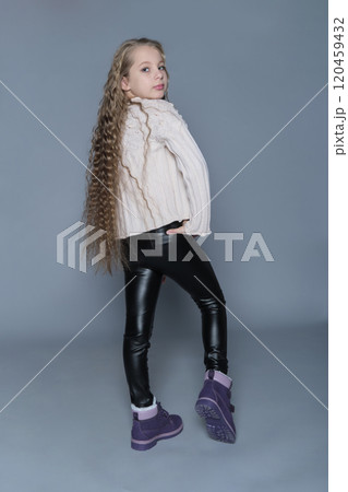 A girl strikes a confident pose in her sweater and dark leggings, exuding natural charm. This portrait highlights the blend of casual style and quiet confidence found in young individuals. A girl strikes a confident pose in her sweater and dark leggings, exuding natural charm. This portrait highlights the blend of casual style and quiet confidence found in young individuals. 120459432