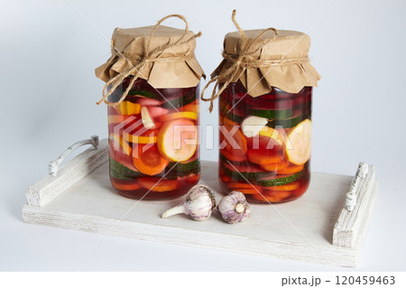 two jars of pickled fermented vegetables on a white wooden tray. winter preparations 120459463