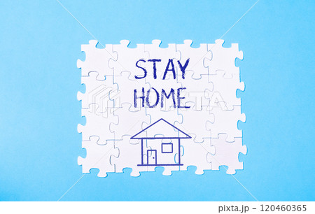 A puzzle with a house on it and the words stay home written in blue 120460365