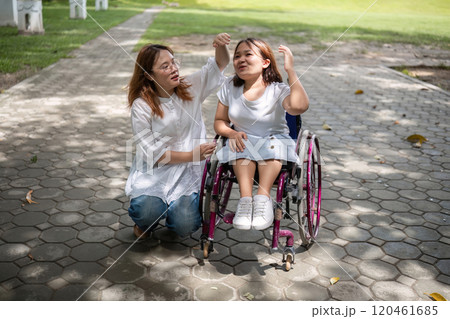 Young Woman in Wheelchair Enjoying a Walk in the Park with Her Best Friend on a Sunny Day Young Woman in Wheelchair Enjoying a Walk in the Park with Her Best Friend on a Sunny Day 120461685