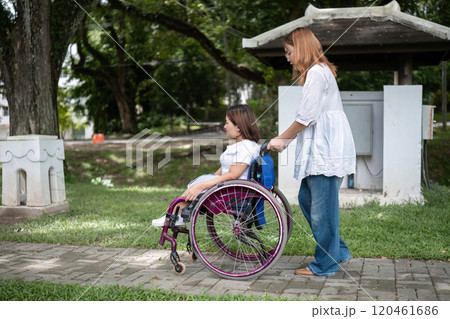 Young Woman in Wheelchair Enjoying a Walk in the Park with Her Best Friend on a Sunny Day Young Woman in Wheelchair Enjoying a Walk in the Park with Her Best Friend on a Sunny Day 120461686