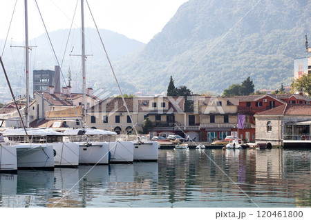 Yachts moored at the coastline in Kotor, Montenegro, with residential buildings and mountains in the background. Yachts moored at the coastline in Kotor, Montenegro, with residential buildings and mountains in the background. 120461800