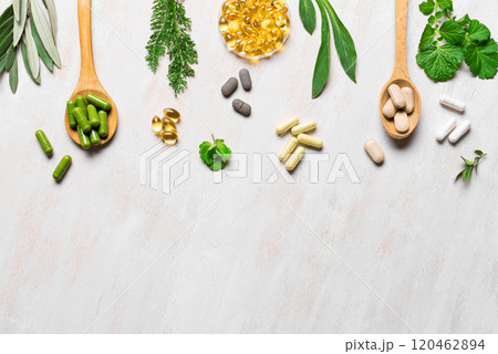 Plant based vitamin capsules and green leaves Plant based vitamin capsules and green leaves 120462894