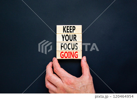 Keep your focus going symbol. Concept words Keep your focus going on beautiful wooden blocks. Businessman hand. Beautiful black background. Business and keep your focus going concept. Copy space. 120464954