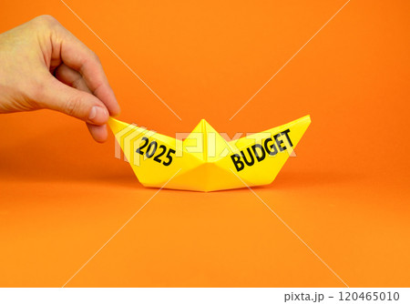 Planning 2025 budget new year symbol. Concept words 2025 Budget on beautiful yellow paper boat. Beautiful orange paper background. Businessmen hand. Business 2025 budget new year concept. Copy space. 120465010