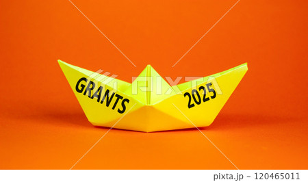 Planning grants 2025 new year symbol. Concept words Grants 2025 on beautiful yellow paper boat. Beautiful orange paper background. Business grants 2025 new year concept. Copy space. 120465011