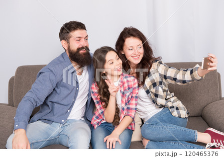 Little girl use smartphone with mother and father. man and woman with little girl. Mother and father do selfie for little girl. Family with little girl. Happy family at home. Collecting memories 120465376