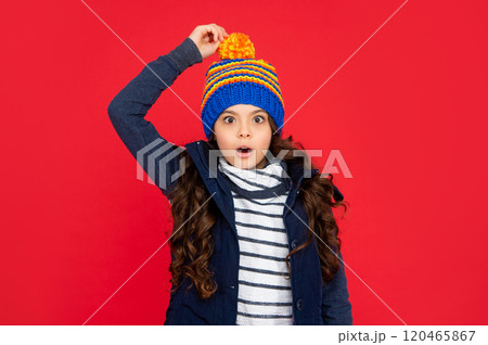 shocked teen girl on red background. portrait of child wearing warm clothes. 120465867