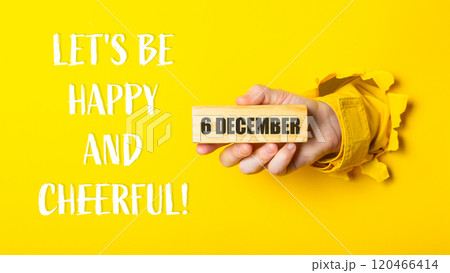 Person holding a block of wood with the words Let's be happy 120466414