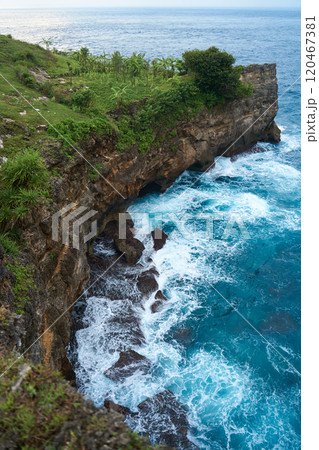 Cinematic aerial landscape shots of the beautiful island of Nusa Penida. Huge cliffs by the shoreline and hidden dream beaches with clear water and foaming wave. 120467381