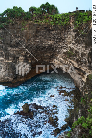 Cinematic aerial landscape shots of the beautiful island of Nusa Penida. Huge cliffs by the shoreline and hidden dream beaches with clear water and foaming wave. 120467383