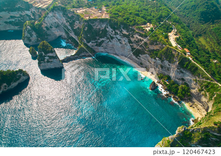 Cinematic aerial landscape shots of the beautiful island Diamond beach of Nusa Penida. Huge cliffs by the shoreline and hidden dream beaches with clear water. 120467423