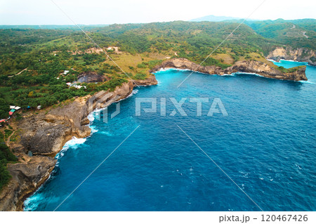 Cinematic aerial landscape shots of the beautiful island of Nusa Penida. Huge cliffs by the shoreline and hidden dream beaches with clear water. 120467426