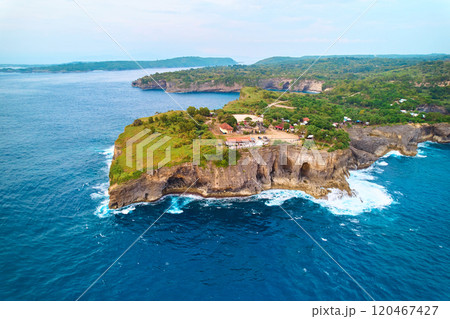 Cinematic aerial landscape shots of the beautiful island of Nusa Penida. Huge cliffs by the shoreline and hidden dream beaches with clear water. 120467427