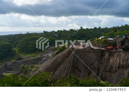 A stone quarry in Indonesia. Large equipment such as bulldozers and dump trucks are working on the site. 120467453