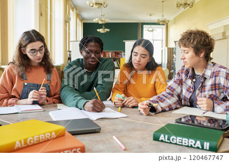Group of diverse students sitting and studying together in classroom, focused on Algebra. Students are collaborating, supporting learning, demonstrating teamwork Group of diverse students sitting and studying together in classroom, focused on Algebra. Students are collaborating, supporting learning, demonstrating teamwork 120467747