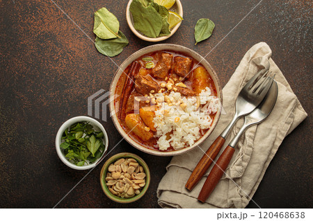Delicious massaman curry with beef, potatoes, rice, and peanuts is served in bowl top view, Thai cuisine Delicious massaman curry with beef, potatoes, rice, and peanuts is served in bowl top view, Thai cuisine 120468638