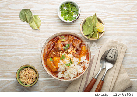 Delicious massaman curry with beef, potatoes, rice, and peanuts on white wooden background, traditional thai cuisine Delicious massaman curry with beef, potatoes, rice, and peanuts on white wooden background, traditional thai cuisine 120468653