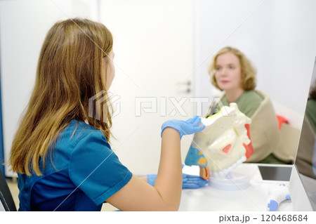 The otolaryngologist explains to the patient about his illness at the appointment. A professional ENT doctor demonstrates a model of the human nose. Treatment of inflammation disease of nose. 120468684