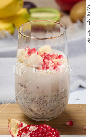 A glass of chia seeds and yogurt, with banana pieces and pomegranate seeds added to the dessert A glass of chia seeds and yogurt, with banana pieces and pomegranate seeds added to the dessert 120468738