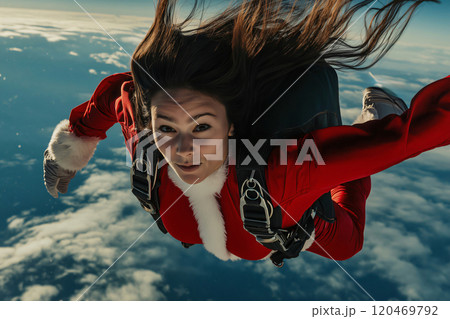 Young woman wearing a santa claus suit is free falling through the air during a skydiving adventure Young woman wearing a santa claus suit is free falling through the air during a skydiving adventure 120469792