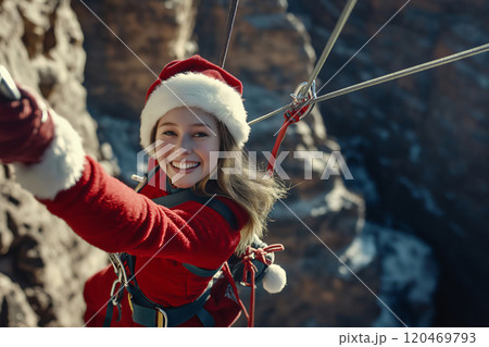 Cheerful young woman dressed as santa claus is taking a selfie while ziplining on a sunny winter day 120469793