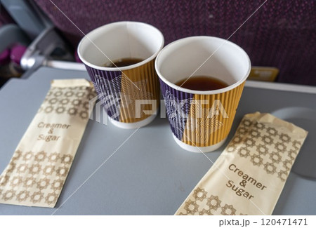 飛行機内テーブルに置かれたコーヒーとクリーマー 120471471