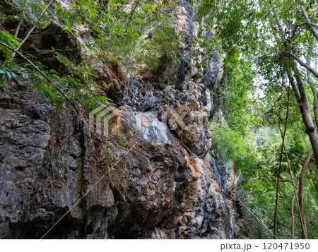 Amazing hillside cliff with compressed layer rock structure of volcanic rock. Close-up texture of volcanic rock. Cracked broken crumbled. 120471950