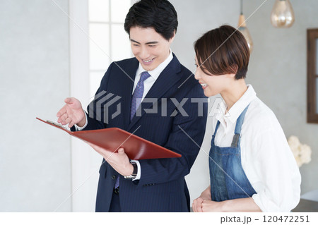物件の内見をする不動産営業マンと開業する女性 120472251