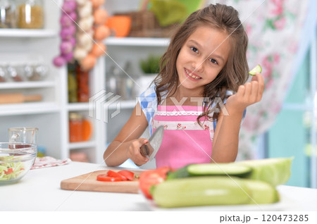 Cute happy girl coocking salad on kitchen 120473285
