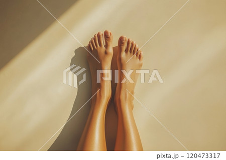 A woman's feet are shown in a close up, with the sun shining on them 120473317