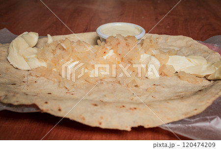 Close up of Nicaraguan Quesillo served on wooden table. Top view of Nicaraguan Quesillo served on wooden table. Traditional Nicaraguan Quesillo served on wooden table Close up of Nicaraguan Quesillo served on wooden table. Top view of Nicaraguan Quesillo served on wooden table. Traditional Nicaraguan Quesillo served on wooden table 120474209