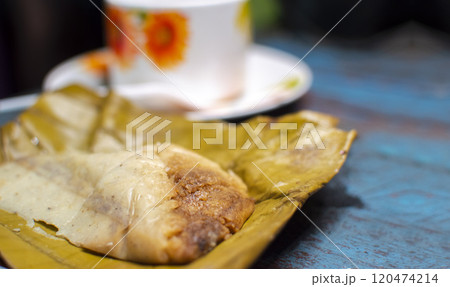 Stuffed tamale served on wooden table, stuffed tamale on banana leaf served on wooden table, typical nicaragua food 120474214