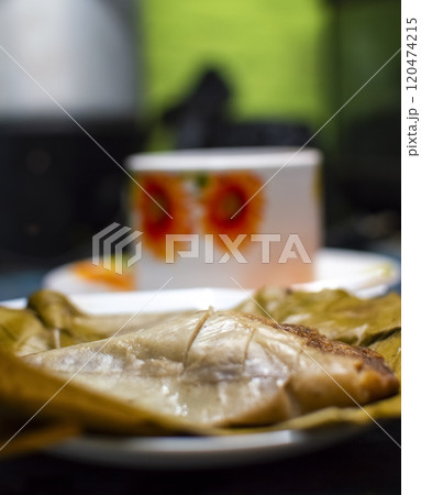 Stuffed tamale served on wooden table, stuffed tamale on banana leaf served on wooden table, typical nicaragua food 120474215