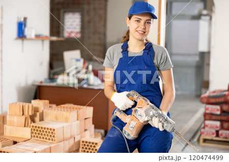 Young woman construction worker standing inside apartment Young woman construction worker standing inside apartment 120474499