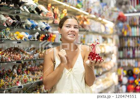 Female tourist chooses figurine of spanish dancer in souvenir shop Female tourist chooses figurine of spanish dancer in souvenir shop 120474551