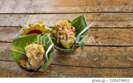 Vigoron with leaves served on a wooden table, two vigorones served on wooden background, vigoron typical food from nicaragua 120474602