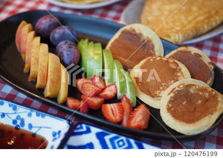 Indulge in a Delightful Breakfast Platter Featuring Fluffy Pancakes and Fresh Assorted Fruits 120476199