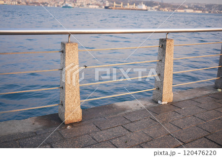 Stunning Seaside Promenade with Sturdy Concrete Railings by the Calm and Peaceful Waters Stunning Seaside Promenade with Sturdy Concrete Railings by the Calm and Peaceful Waters 120476220