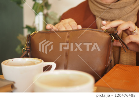 An Elegant Brown Handbag Placed on a Cafe Table Surrounded by Coffee Cups and More An Elegant Brown Handbag Placed on a Cafe Table Surrounded by Coffee Cups and More 120476488