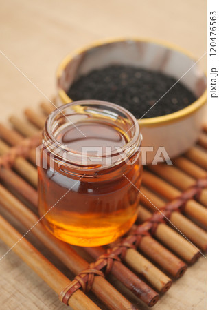 Black Seeds and Their Oil Beautifully Arranged in a Rustic Wooden Bowl for Culinary Uses Black Seeds and Their Oil Beautifully Arranged in a Rustic Wooden Bowl for Culinary Uses 120476563