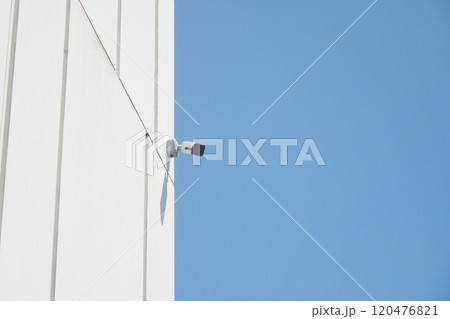 Surveillance Camera Mounted on Building Against Clear Blue Sky Surveillance Camera Mounted on Building Against Clear Blue Sky 120476821