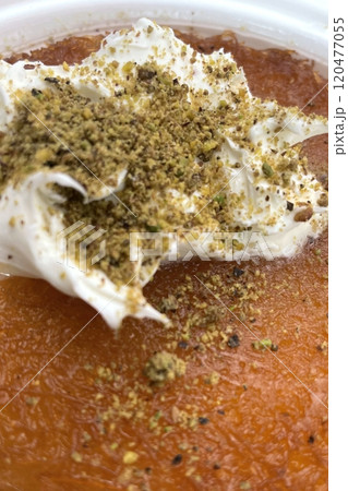 Traditional Turkish Dessert Kunefe with Clotted Cream and Crushed Pistachios.The image shows a portion of Kunefe, a traditional Turkish dessert. The knefe is topped with clotted cream Traditional Turkish Dessert Kunefe with Clotted Cream and Crushed Pistachios.The image shows a portion of Kunefe, a traditional Turkish dessert. The knefe is topped with clotted cream 120477055