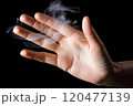 Smoke from a cigarette in the hand on a black background. Selective Focus 120477139