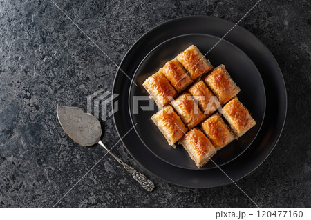 Baklava with walnuts on a blackstone table. 120477160